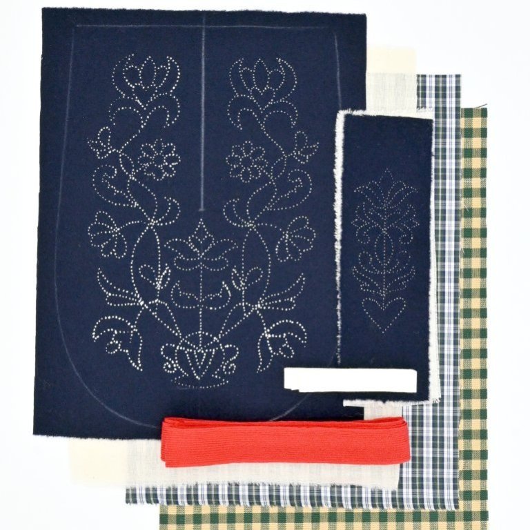 Each kit contains two printed wool fabrics, calico backing fabric, cotton lining for the front piece, thick cotton fabric for the back, wool binding for the edges, wool embroidery thread and a needle. Other notions that are not included but needed are a good pair of scissors and sewing thread in a bright colour.