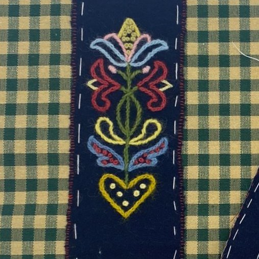 Take the hidden flower, position on the thick cotton back so that it can just be seen through the slit and stitch onto the cotton back.