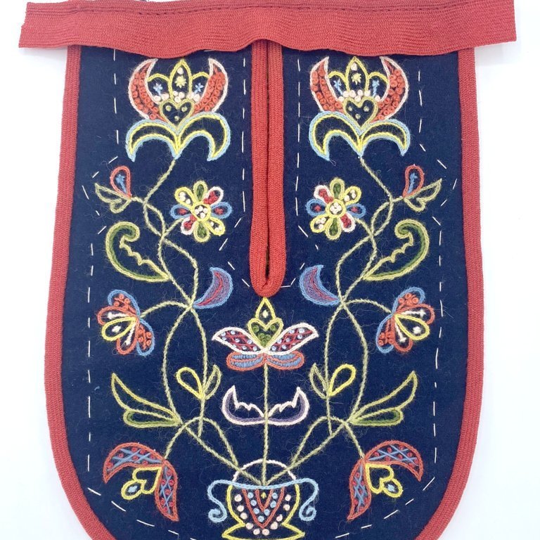 Bind the top edge of the pocket and secure the ends by folding them in under the binding.